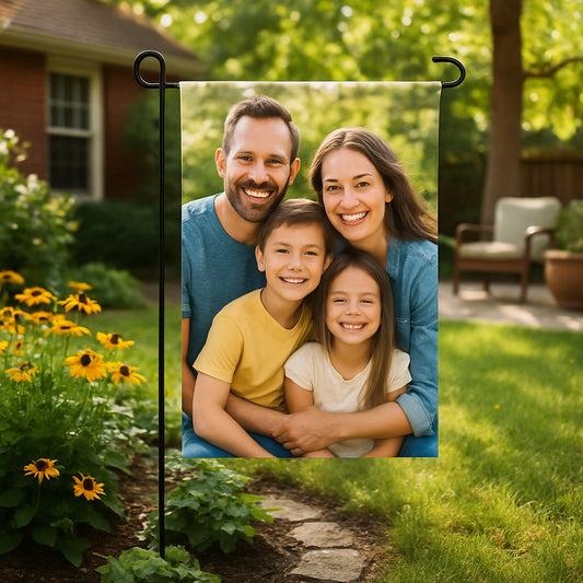 A cozy backyard scene featuring a vibrant, personalized garden flag with a smiling family photo, fluttering gently in the breeze. Alt: Custom photo garden flag gift showing a happy family outdoors.
