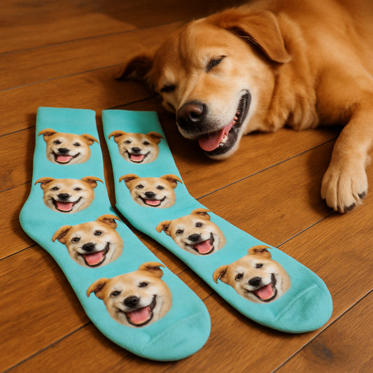 A cozy pair of personalized pet face socks resting on a wooden floor next to a happily napping dog. Alt: Personalized pet face socks showcasing a detailed, lifelike image of a happy dog’s face.