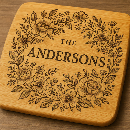 Close-up of a beautifully engraved custom bamboo cutting board featuring a family name and floral design. Alt: Custom engraved bamboo cutting board gift with family name and intricate design.
