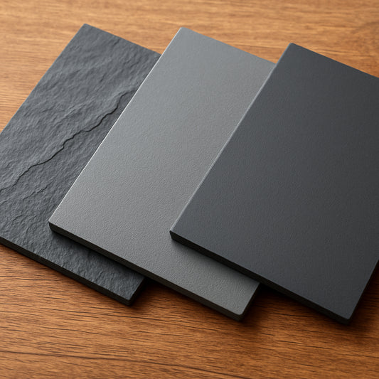 A close‑up of three different slate materials – natural slate with veining, smooth engineered stone, and lightweight polymer composite, arranged on a wooden table. Alt: custom photo slate material comparison showing texture and finish.