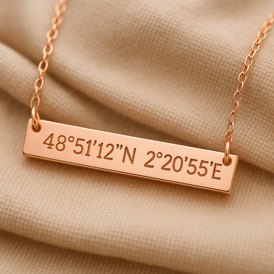 A close-up photo of an elegant custom coordinates necklace engraved in rose gold resting on soft fabric. Alt: Custom coordinates necklace gift in rose gold with engraved latitude and longitude.