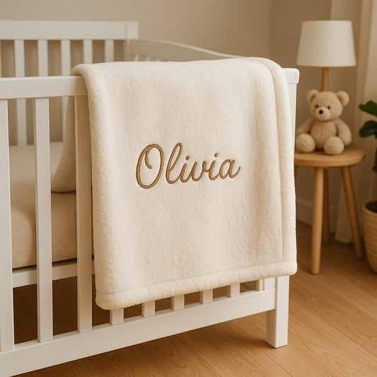 A cozy personalized baby blanket with embroidered name in a nursery setting. Alt: Soft personalized baby blanket gift embroidered with baby's name.